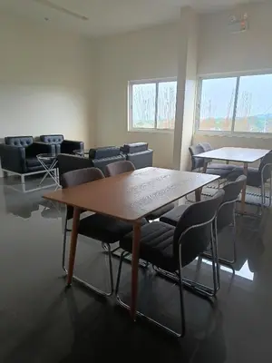 a conference room with tables and chairs and windows at Miranda's Suite by Fullerton in Silang