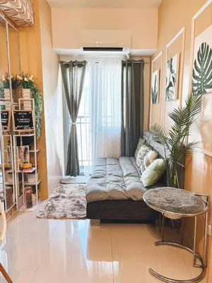 a large couch in a room with a window at El Romantico Staycation at Fame Residence in Manila