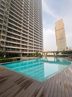 a large swimming pool in front of a large building at El Romantico Staycation at Fame Residence in Manila