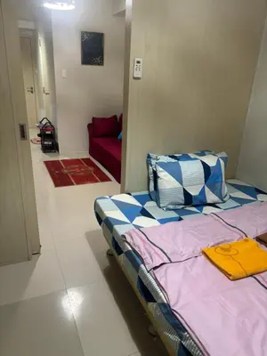 a bedroom with a bed and a red couch at Joie Selene in Manila