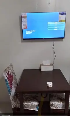 a table with a computer monitor on a wall at Joie Selene in Manila