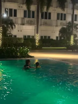 two children swimming in a swimming pool at night at Joie Selene in Manila