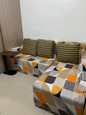 a couch with pillows on it in a room at Shore Residences in Manila
