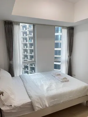 a bed in a bedroom with a large window at Venetian Haven BGC Venice Grand Canal Apart ment, 4 Bedrooms, for 10 Guests in Manila