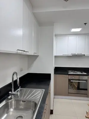 a kitchen with white cabinets and a sink at Venetian Haven BGC Venice Grand Canal Apart ment, 4 Bedrooms, for 10 Guests in Manila