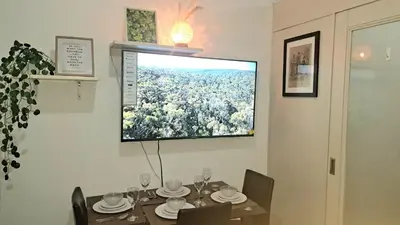 a dining room with a table and a television on the wall at Searendipity - Sea Residences, Pasay City in Manila