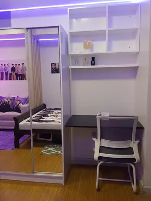 a room with a mirror and a bed and a chair at House of Bangtan at Grace Residences, Taguig in Manila