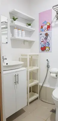 a white bathroom with a sink and a toilet at House of Bangtan at Grace Residences, Taguig in Manila
