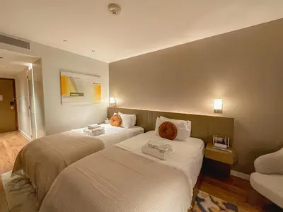 a hotel room with two beds with towels on them at Rockwell View Twin Suite with FREE WiFi Pool & Gym in Manila