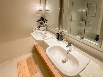 a bathroom with two sinks and a shower at Rockwell View Twin Suite with FREE WiFi Pool & Gym in Manila