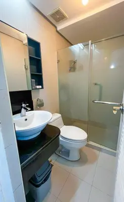 a bathroom with a toilet and a sink and a shower at Le Grand one in Manila