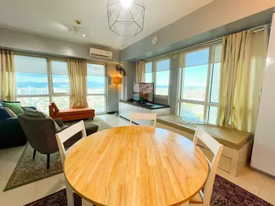 a living room with a wooden table and chairs at Le Grand one in Manila