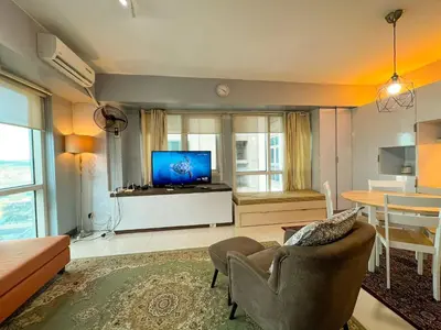 a living room with a television and a couch and a table at Le Grand one in Manila
