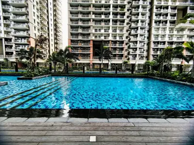 a large blue swimming pool in front of a building at Vincondotel Near BGC 2BR Fairlane in Manila