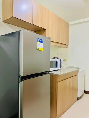 a kitchen with a refrigerator and a microwave at Fairlane Residences in Manila