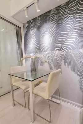 a glass table and two chairs in front of a wall at Azure Urban Residences by Lyn in Manila