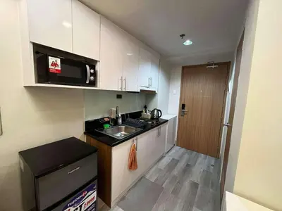a small kitchen with a sink and a microwave at Stylish and Modern Suite with Pool Access and Parking in Manila