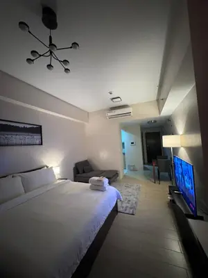 a bedroom with a bed and a couch and a television at 81 Newport Blvd Cluster 4 Unit 10C by Rechelle Nunag in Manila