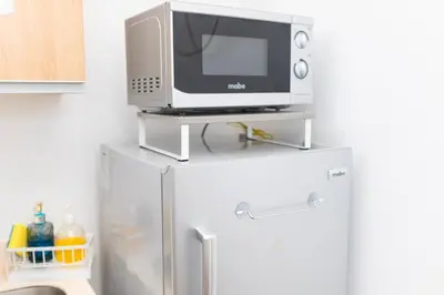 a microwave sitting on top of a refrigerator at 1Bedroom Beach View with Netflix near Airport in Manila
