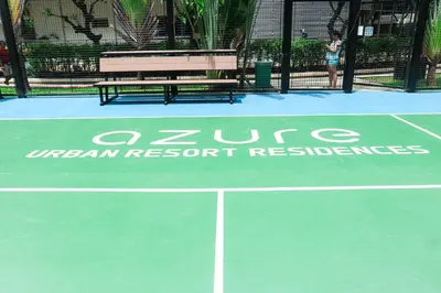 a tennis court with a bench on a tennis court at 1Bedroom Beach View with Netflix near Airport in Manila