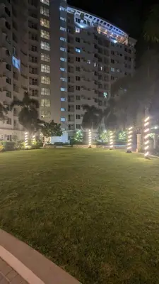 a park at night with tall buildings and a grass field at Cozy Studio Suite in Muntinlupa in Manila