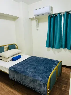 a bed in a room with blue curtains at Vincondotel Near BGC 3BR Fairlane in Manila
