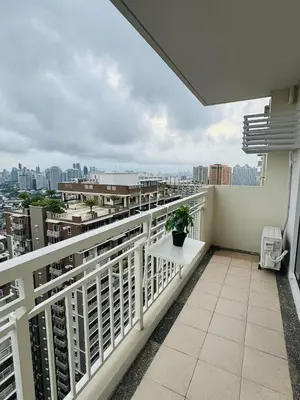 a balcony with a table and a view of a city at Vincondotel Near BGC 3BR Fairlane in Manila