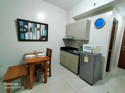 a small kitchen with a table and a microwave at Sonia Suite at The Beacon Makati in Manila