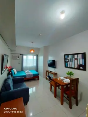 a living room with a couch and a bed and a table at Sonia Suite at The Beacon Makati in Manila