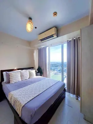 a bedroom with a large bed and a large window at Azure Urban Residences By Lyn 2BR in Manila