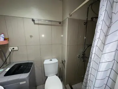 a small bathroom with a toilet and a shower at Shell Residence Condotel in Manila