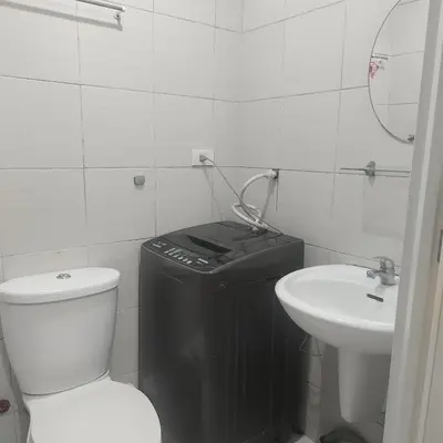 a white bathroom with a toilet and a sink at Budget Family Group Room for 4 persons in Manila