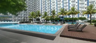 a swimming pool in front of a large building at Budget Family Group Room for 4 persons in Manila