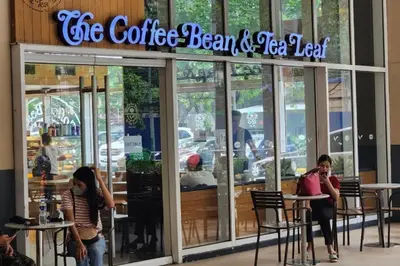 people sitting at tables outside of a coffee bean and tea cafe at Budget Family Group Room for 4 persons in Manila