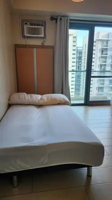 a bed in a room with a large window at Casa Antonio at 7i Two Palm Tree Villas Beside NAIA3 in Manila