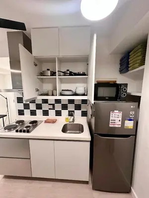 a small kitchen with a sink and a refrigerator at Azure 2Br 1Ba with City View Balcony and Free Parking in Manila
