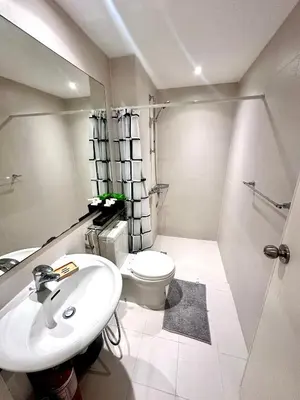 a white bathroom with a toilet and a sink at Azure 2Br 1Ba with City View Balcony and Free Parking in Manila