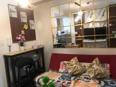 a room with a bed and a desk and a mirror at 3M Staycation in Manila