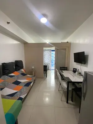 a bedroom with a bed and a desk and a table at Sea Residences MOA Pasay City - Reynil in Manila