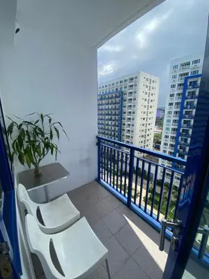a balcony with two chairs and a table and a window at Sea Residences MOA Pasay City - Reynil in Manila