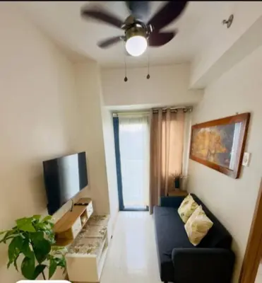 a living room with a couch and a ceiling fan at JL shore Staycation in Manila