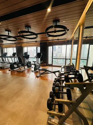 a gym with rows of exercise equipment and windows at Hotel Apartment Suite near Makati in Manila