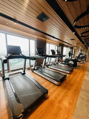 a gym with a row of treadmills in a room at Hotel Apartment Suite near Makati in Manila