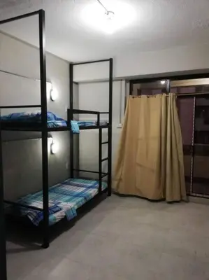 a room with three bunk beds and a curtain at Manila Real Residences 8C in Manila