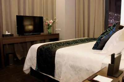 a hotel room with a bed and a flat screen tv at Golden Phoenix Hotel - Manila in Manila