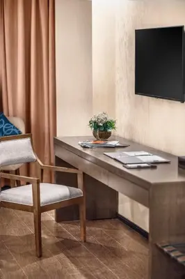 a room with a table with a television on a wall at Golden Phoenix Hotel - Manila in Manila
