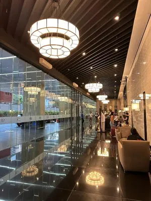 a lobby with glass walls and chandeliers in a building at Affordable Ayala Makati 1BR Condo in Manila