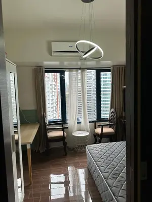 a bedroom with a bed and a desk and some windows at Affordable Ayala Makati 1BR Condo in Manila