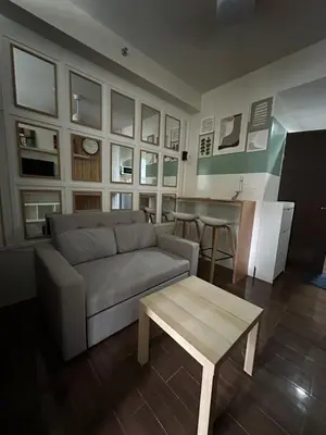 a living room with a couch and a table at Affordable Ayala Makati 1BR Condo in Manila