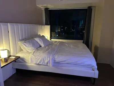 a bedroom with a white bed with a window at King-size Bed Makati Condo in Manila